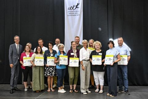 Gruppenbild mit Ministerin Dorothee Feller und Startchancen-Schulleitungen, die ihre Plaketten in den Händen halten.