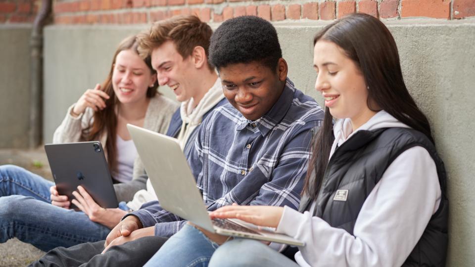 Jugendliche mit Laptops unterhalten sich Jugendliche mit Laptops unterhalten sich