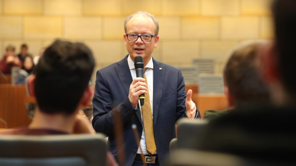 Der Präsident des Landtag, André Kuper, spricht zu Schülerinnen und Schülern.