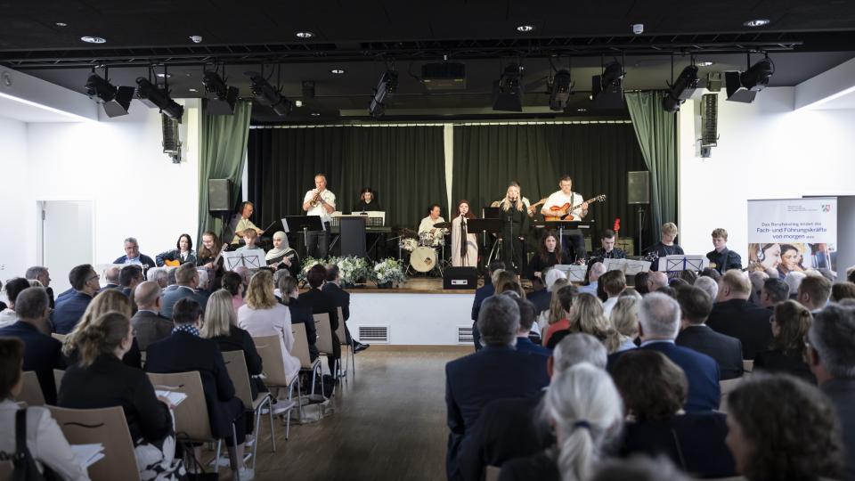 Blick aus dem Publikum auf die Bühne, auf der eine Musikgruppe während des Festaktes zum 25-jährigen Jubiläum der Berufskollegs spielt.