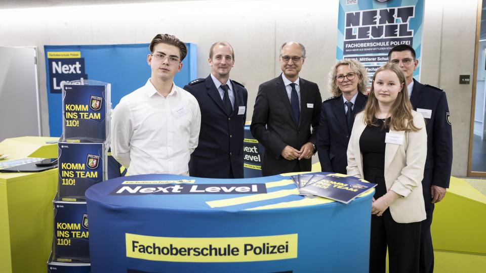 Gruppenbild mit Staatssekretär Dr. Urban Mauer beim Besuch des Standes der Fachoberschule Polizei.