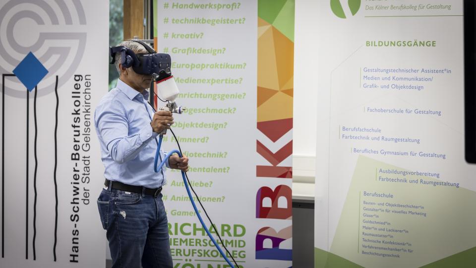 Ein Gast der Jubiläumsveranstaltung führt den Einsatz einer VR-Brille vor.