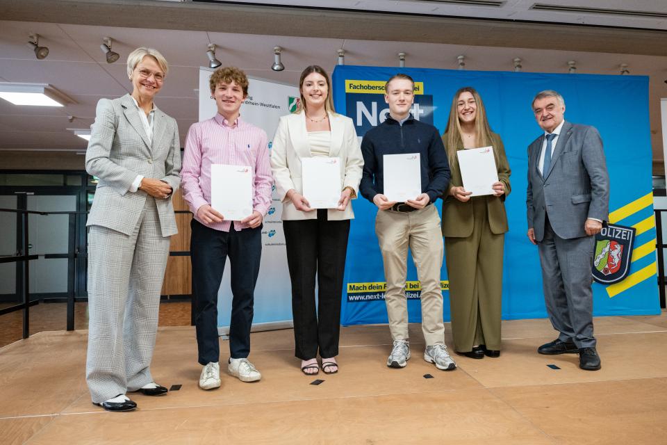 Ministerin Dorothee Feller im Gespräch mit einer Absolventin der FOS-Polizei, die ihr Abschlusszeugnis in der Hand hält.