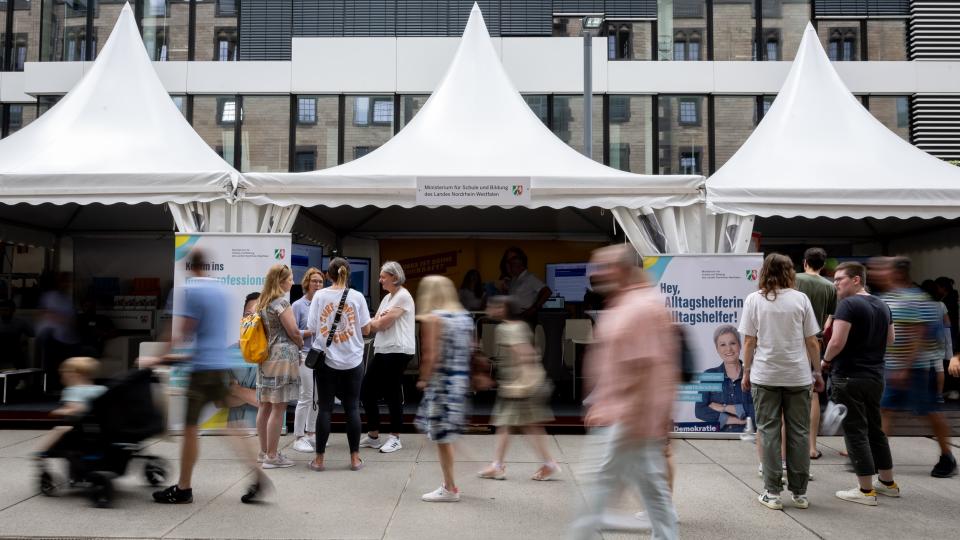 Besucherinnen und Besucher vor den Zelten des Schulministeriums am NRW-Tag 2024 in Köln.