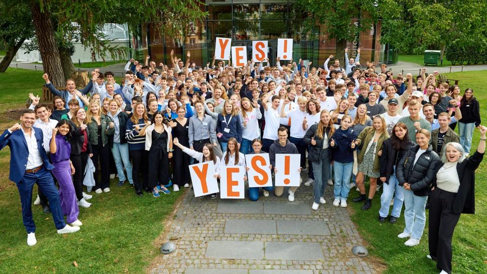 Die Teilnehmenden am Finale des Wettbewerbs Young Economic Solutions 2023 stehen beieinander und halten Schilder mit der Aufschrift YES! in die Höhe.