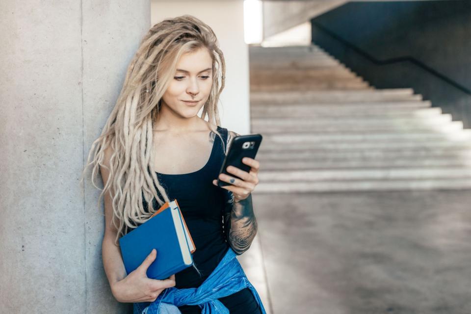 Schülerin blickt auf ein Smartphone. Schülerin blickt auf ein Smartphone.