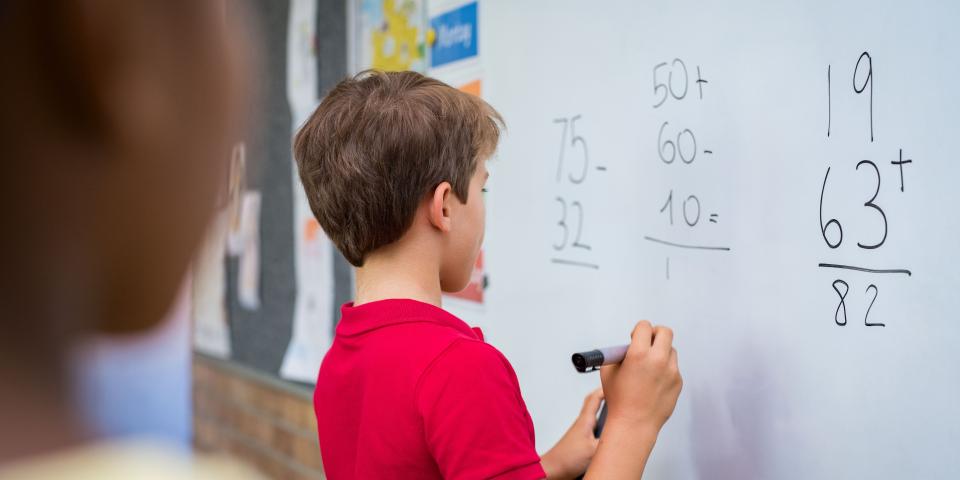 Grundschüler löst eine Mathematikaufgabe an der Tafel. Grundschüler löst eine Mathematikaufgabe an der Tafel.