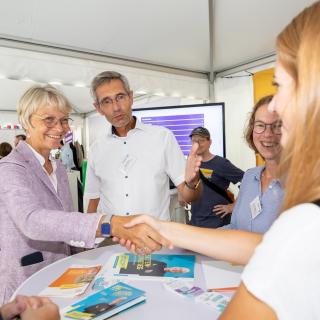 Schulministerin Dorothee Feller begrüßt am Samstagnachmittag eine Besucherin am Stand des Schulministeriums.