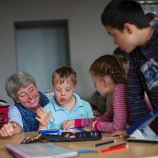 Lehrerin und Kinder mit und ohne Behinderung in Unterrichtssituation Lehrerin und Kinder mit und ohne Behinderung in Unterrichtssituation